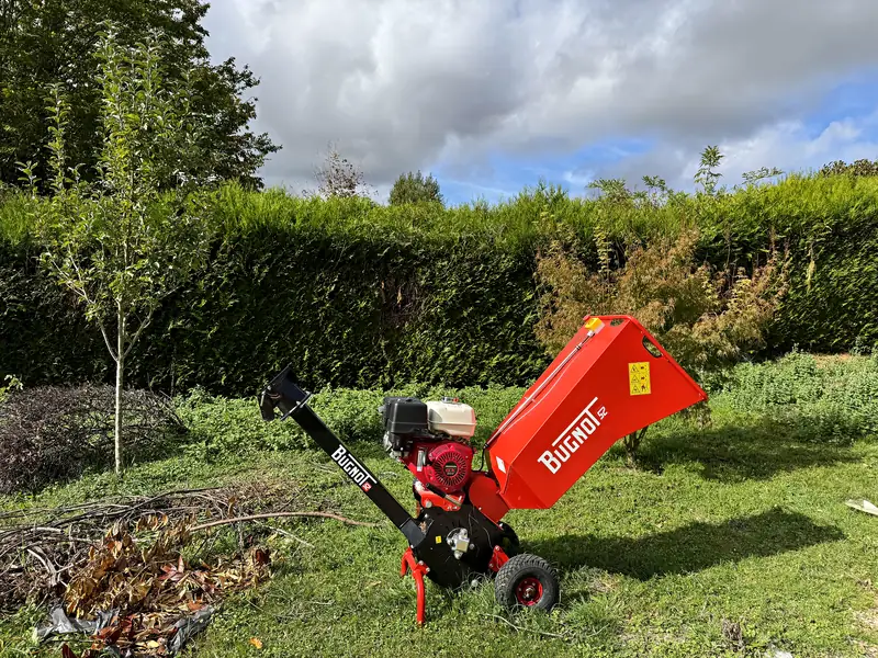 Le broyeur de végétaux Sakura Home au pôle technique de Magny-en-Vexin, à côté d'un tas de branches