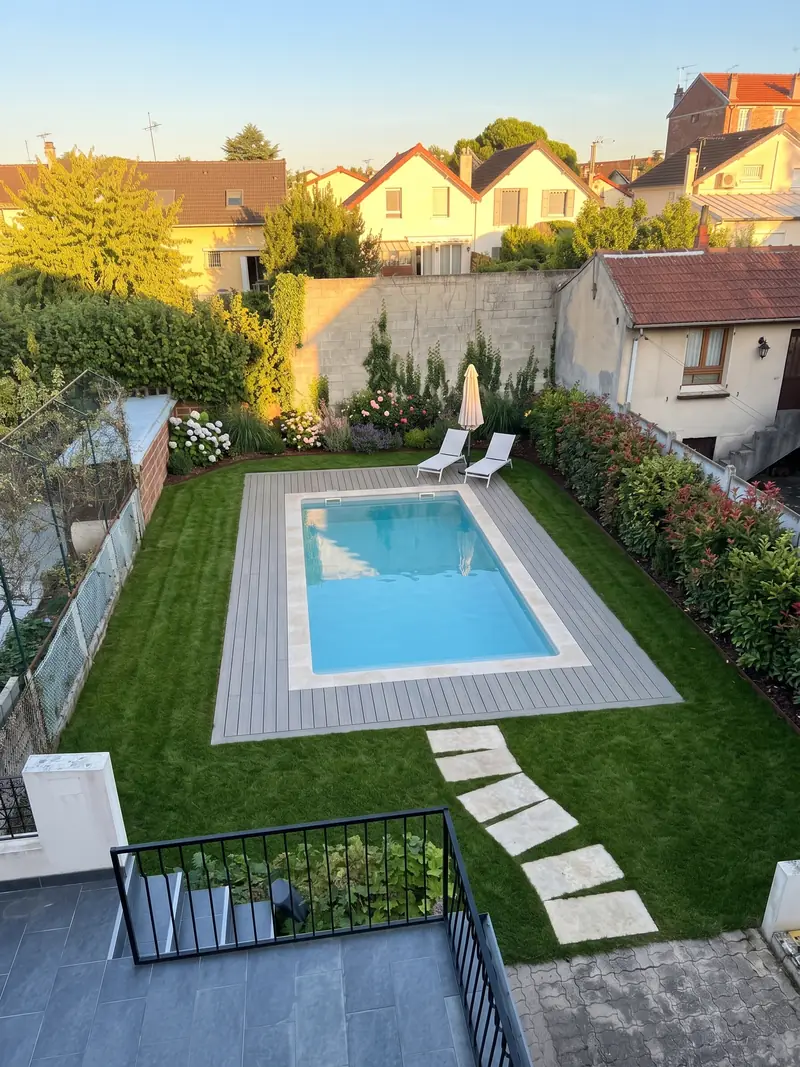 Simulation de la proposition 1 : piscine rectangulaire avec plage en bois, haie de photinias, massif fleuri au fond